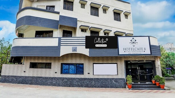 A multi-story hotel with a modern facade, a sign for 'HOTELCAFE 8,' and a company-serviced logo. - Super Collection O Hingna Road (Nagpur)
