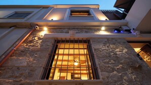 A stone building with a window, a door, and a small balcony. - Diastar Boutique (Heraklion)