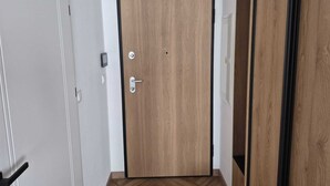 Una puerta de madera con marco negro, un pomo plateado y una cerradura.