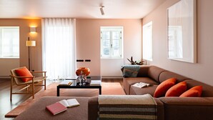 Ein modernes Wohnzimmer mit einer Couch, einem Sessel, einem Couchtisch und einer Lampe.