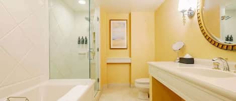 Un baño moderno con cabina de ducha de vidrio, un espejo grande y un lavamanos blanco.