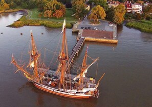 Un grand voilier était amarré à un quai, avec une vue sur la ville en arrière-plan.