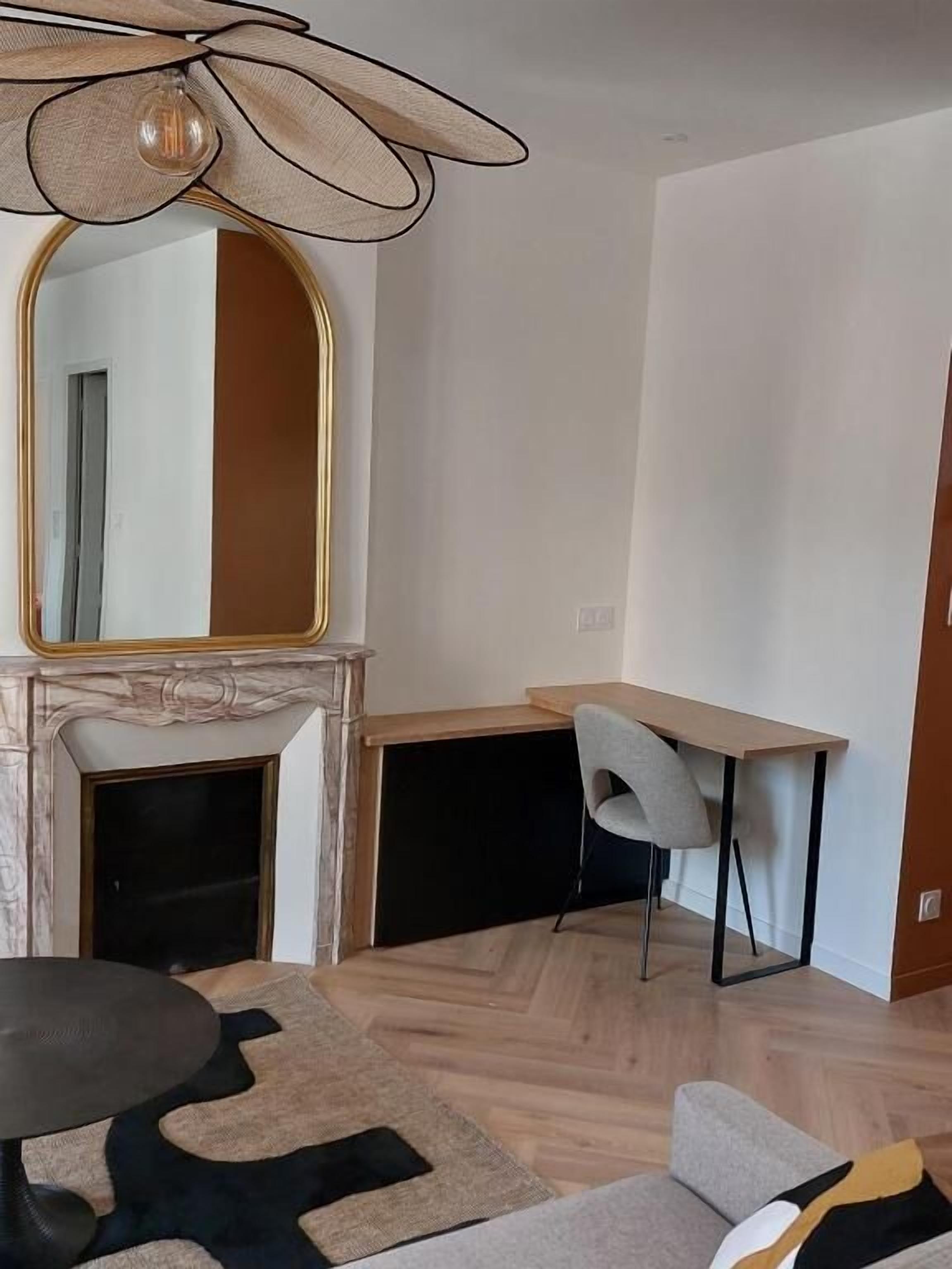 Ein modernes Zimmer mit Kamin, einem Esstisch, einem Sessel und einer Couch.