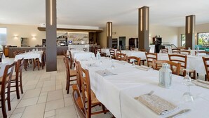 A restaurant with multiple tables, chairs, and a bar area.
