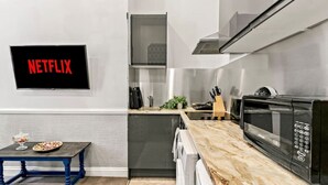 Une cuisine moderne équipée d’un four à micro-ondes encastré, d’un four à porte en verre et d’un logo Netflix sur le mur.