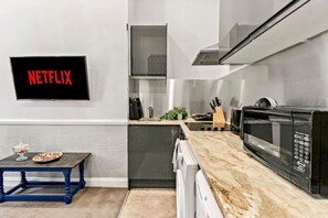 Eine moderne Küche mit integriertem Mikrowellenherd, einem Backofen mit Glastür und einem Netflix-Schild an der Wand.