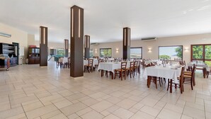 A spacious dining area with multiple tables and chairs, large pillars, and a view of the outdoors. - Villa Ristòries Room 7 with Terrace, Wi-Fi, and Air Conditioning (Matera)