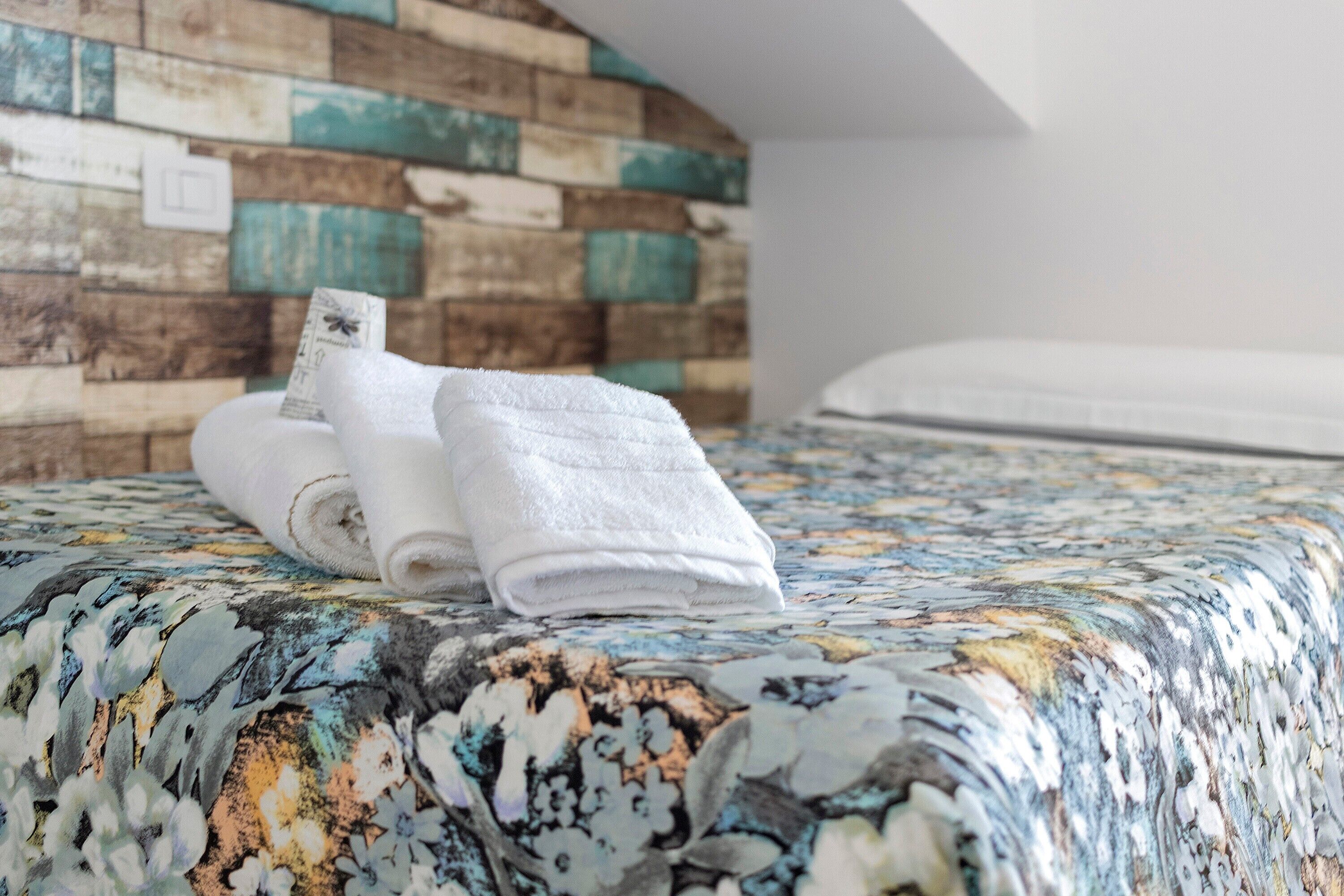 Een bed met een bloemenprint deken en een houten hoofdbord.