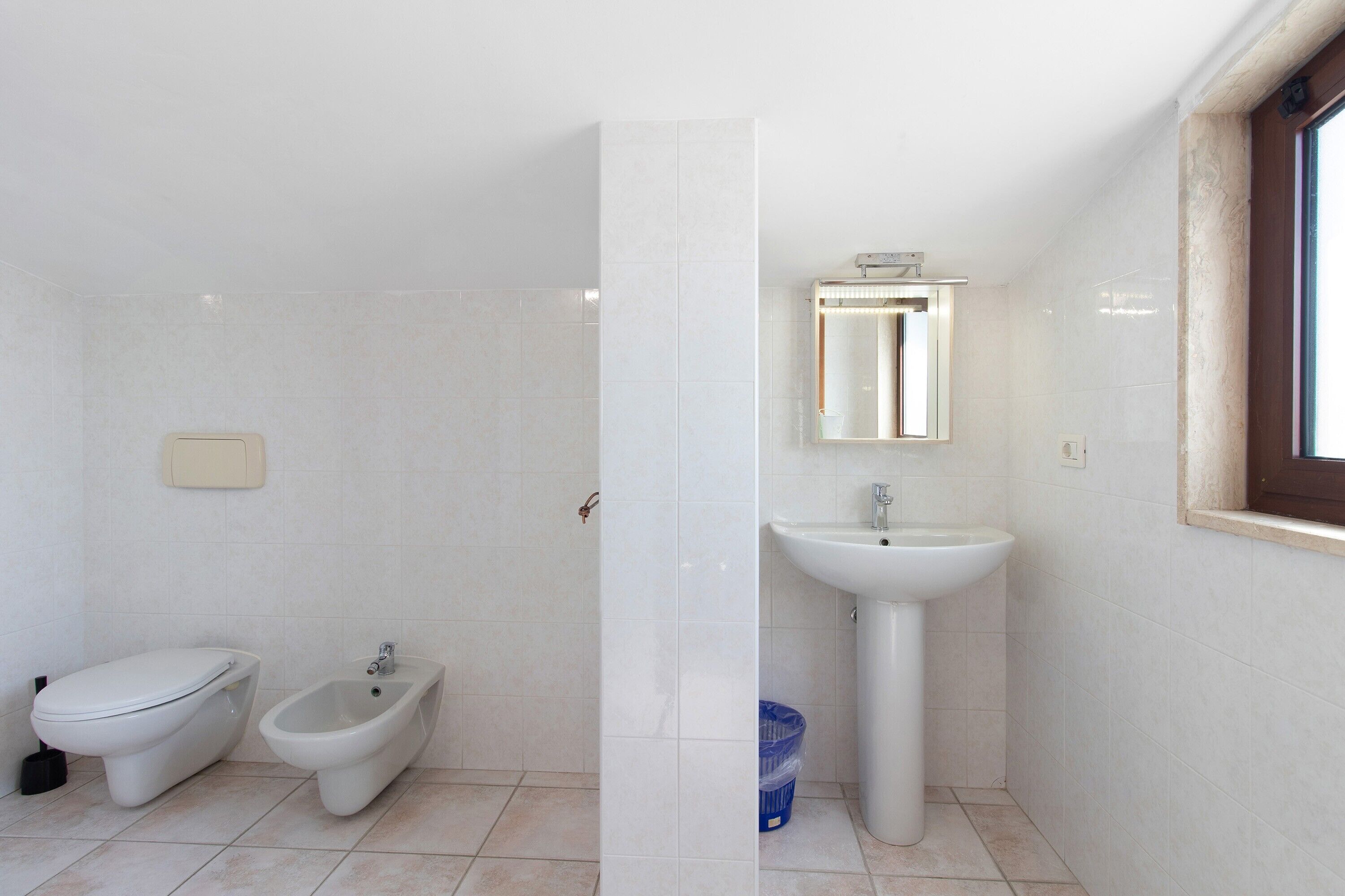 Un bagno con il water, un bidet e un lavandino.