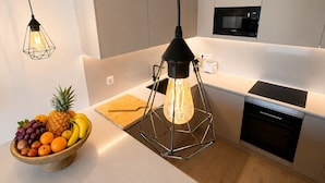 Une cuisine moderne dotée d’un îlot central, d’un four à micro-ondes et d’un four encastré.