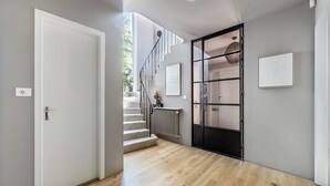 Ein modernes Interieur mit Treppe, Heizkörper und Tür.