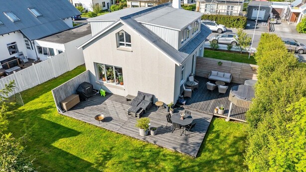 A modern house with a deck, outdoor furniture, and a small garden. - Modern and family friendly house in Reykjavik (Reykjavík)