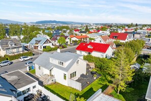 Ein Wohngebiet mit Häusern, einer Straße und einer weiter entfernten Stadtlandschaft.