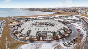 Ett cirkelformat bostadskomplex med en central innergård, omgivet av en väg och en vattenyta.