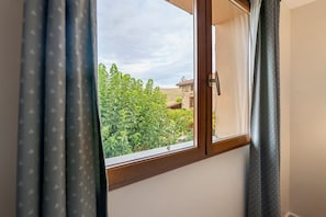 A window with a view of a green landscape and a building with a red roof. - Bed and Breakfast 'Chevreuil' with Shared Pool, Shared Garden and Wi-Fi (Hauterives)