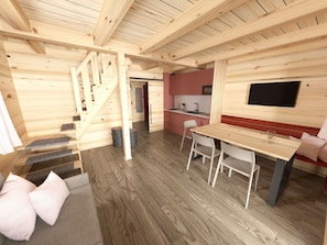 Ein Holzblockhaus-Innenraum mit Treppe, Küchenzeile und Essbereich.