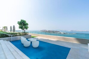 Terraza en la azotea con piscina, zona de estar y vistas a la costa.