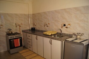 Une cuisine équipée d’une cuisinière, d’un four, d’un évier et d’un lave-vaisselle.