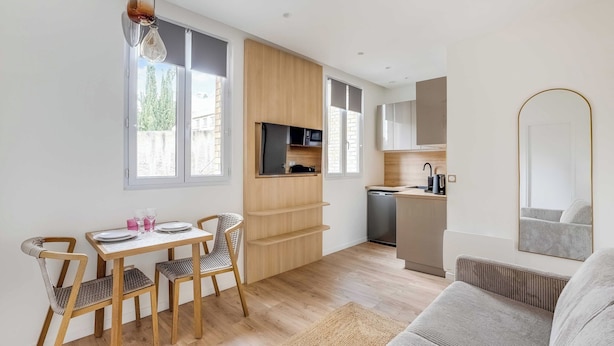 Una cucina moderna con mobili in legno, forno a microonde integrato e lavastoviglie.