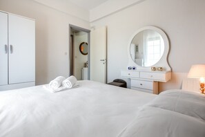 Una habitación de hotel con una cama, un aparador, un espejo y una lámpara.