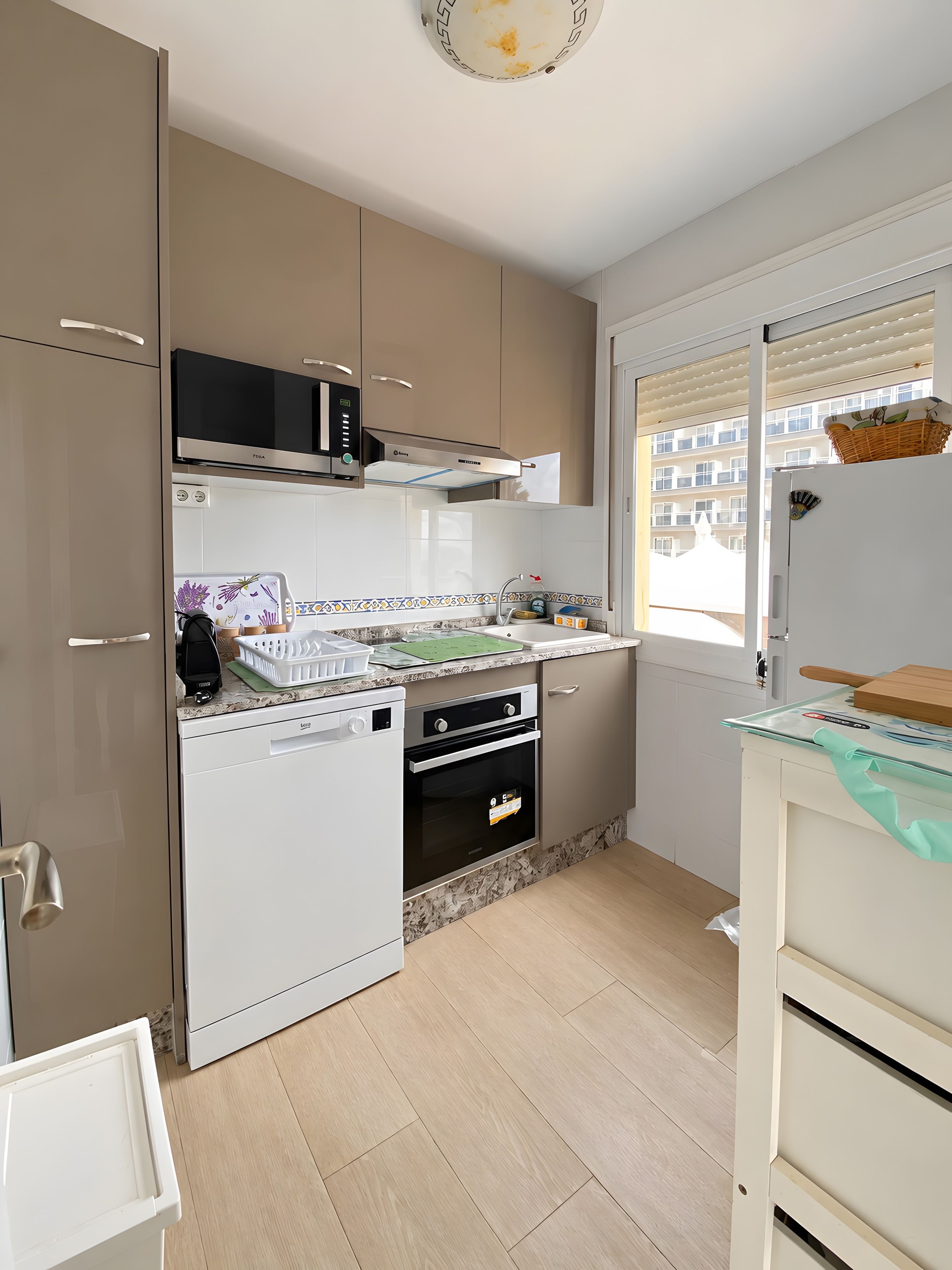 Una cocina compacta equipada con lavavajillas, horno y microondas.