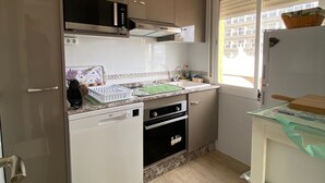 A compact kitchen with a microwave, oven, and sink. - Terrace with Sea Views at Castillo Bil Bil, Benalmádena (Benalmádena)