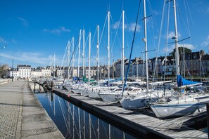 A marina with multiple boats docked along a waterfront, a clear sky, and buildings in the background. - Apartment in a castle with pool – 4 guests (Baden)