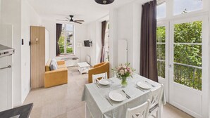 A modern kitchen with a dining area, a sofa, and a table set for two. - Apartment in a castle with pool – 4 guests (Baden)