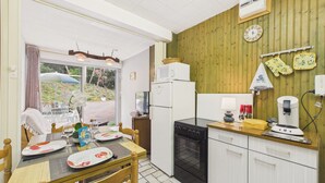 A kitchen with a dining table, chairs, a refrigerator, an oven, and a microwave. - 700 m from beach , flat for 4 with terrace (Jard-sur-Mer)