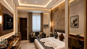 Een moderne hotelkamer met een bed, een bureau, een televisie en een plafondventilator.