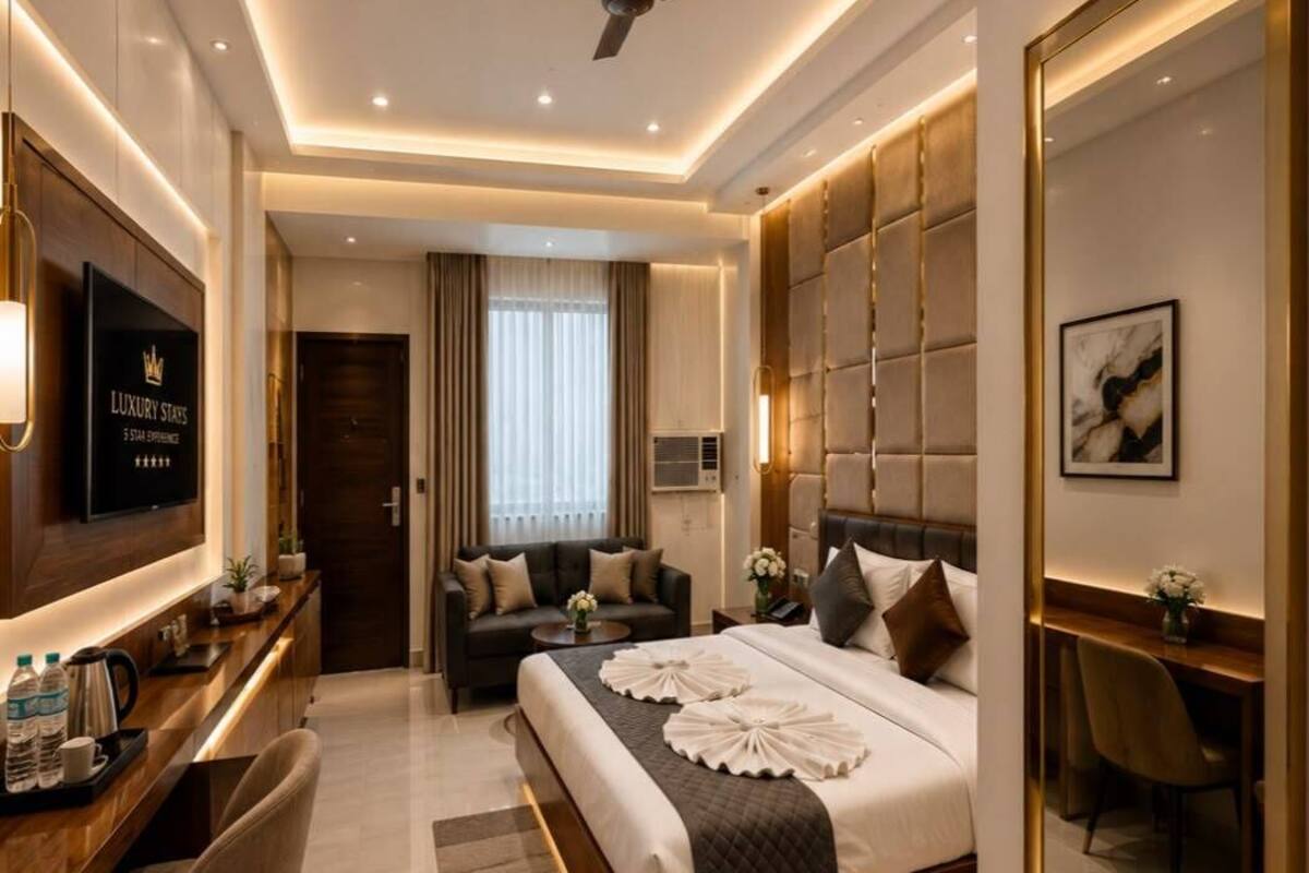 Ein modernes Hotelzimmer mit Bett, Schreibtisch, Fernseher und Deckenventilator.