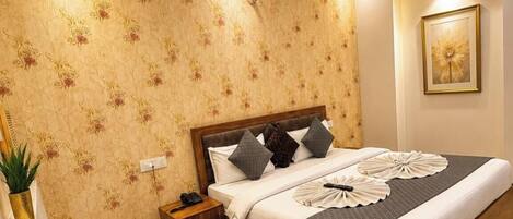 A bedroom with a bed, bedside table, nightstand, and a ceiling fan.