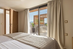 A bedroom with a large bed, a sliding glass door to a balcony, and a view of the outdoors. - Ark Luxury Suite with Hot tub and Sea Views (Zakynthos)