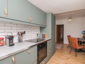 A modern kitchen with a built-in oven, a toaster, and a coffee machine. - Bay Cottage (Redcar)