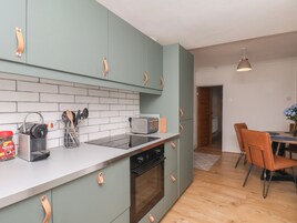 A modern kitchen with a built-in oven, a toaster, and a coffee machine.