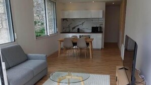 Un salon moderne avec un canapé, une table basse en verre et un meuble pour la télévision.