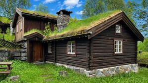 A wooden cabin with a stone chimney, a thatched roof, and a stone foundation. - Mountain cabin 4 in Ål with sauna (Ål)