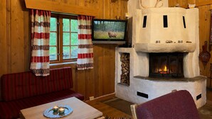 A cozy cabin interior with a fireplace, wooden walls, a television, and a sofa. - Mountain cabin 4 in Ål with sauna (Ål)