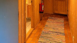 A wooden hallway with a fire extinguisher, a door, and a ceiling light fixture. - Mountain cabin 4 in Ål with sauna (Ål)