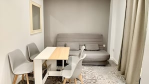 Una habitación moderna con sofá, una mesa y dos sillas.