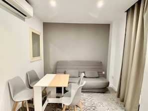 Ein modernes Zimmer mit einer Sitzecke, einem Tisch und zwei Stühlen.