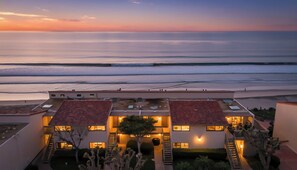 Ein Hotel direkt am Strand mit mehreren Gebäuden, einem Pool und Blick auf das Meer.