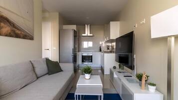 Un apartamento moderno con sala de estar, kitchenette y comedor.