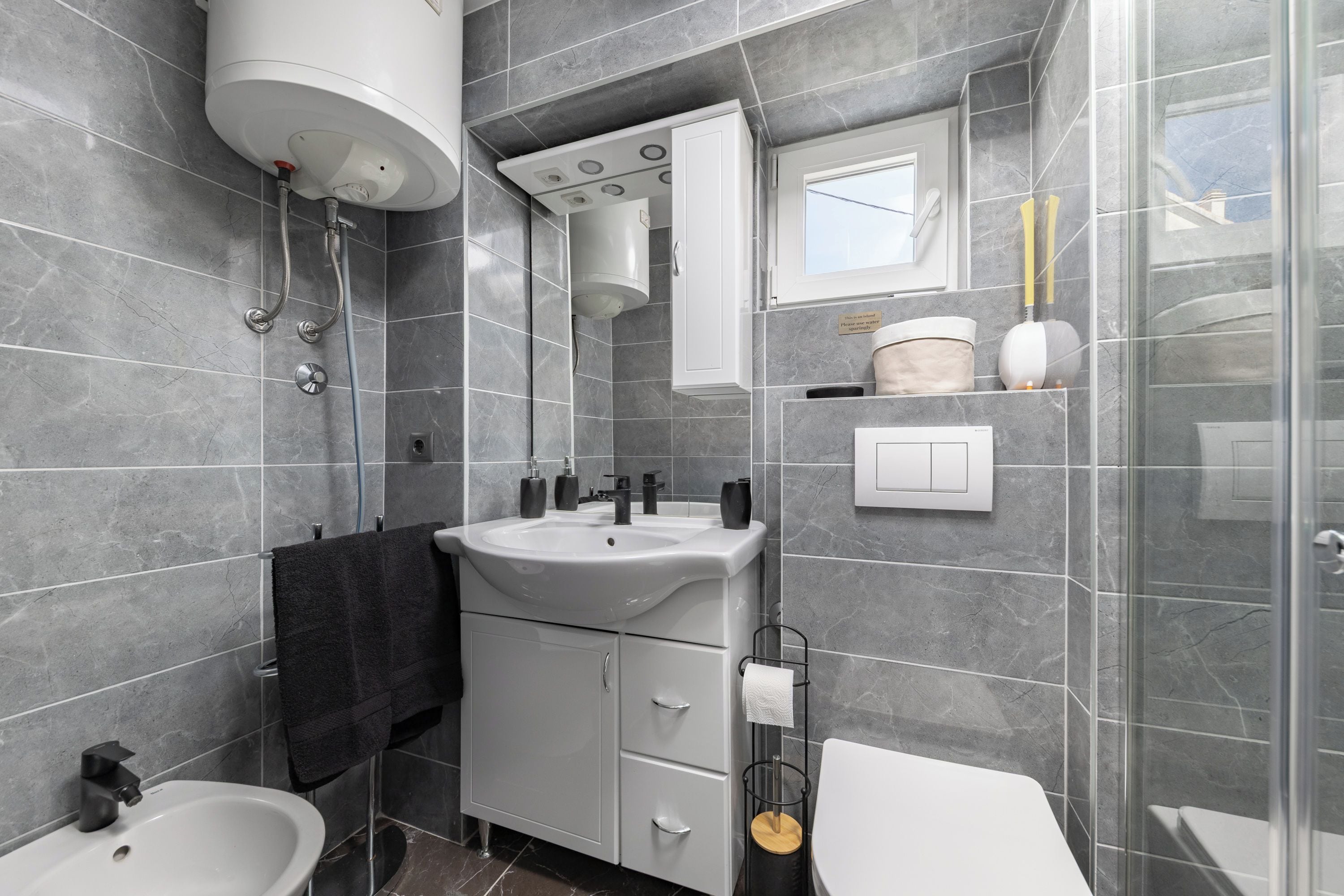 Ein modernes Badezimmer mit Badewanne, Waschbecken, Toilette und Duschbereich.