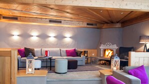 Una sala de estar acogedora con chimenea, techo de madera y muebles modernos.