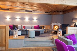 Una sala de estar acogedora con chimenea, techo de madera y muebles modernos.
