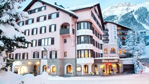 Un hotel de varios pisos con fachada rosa, múltiples balcones y un letrero que dice 'HOTEL ROSATZ'.