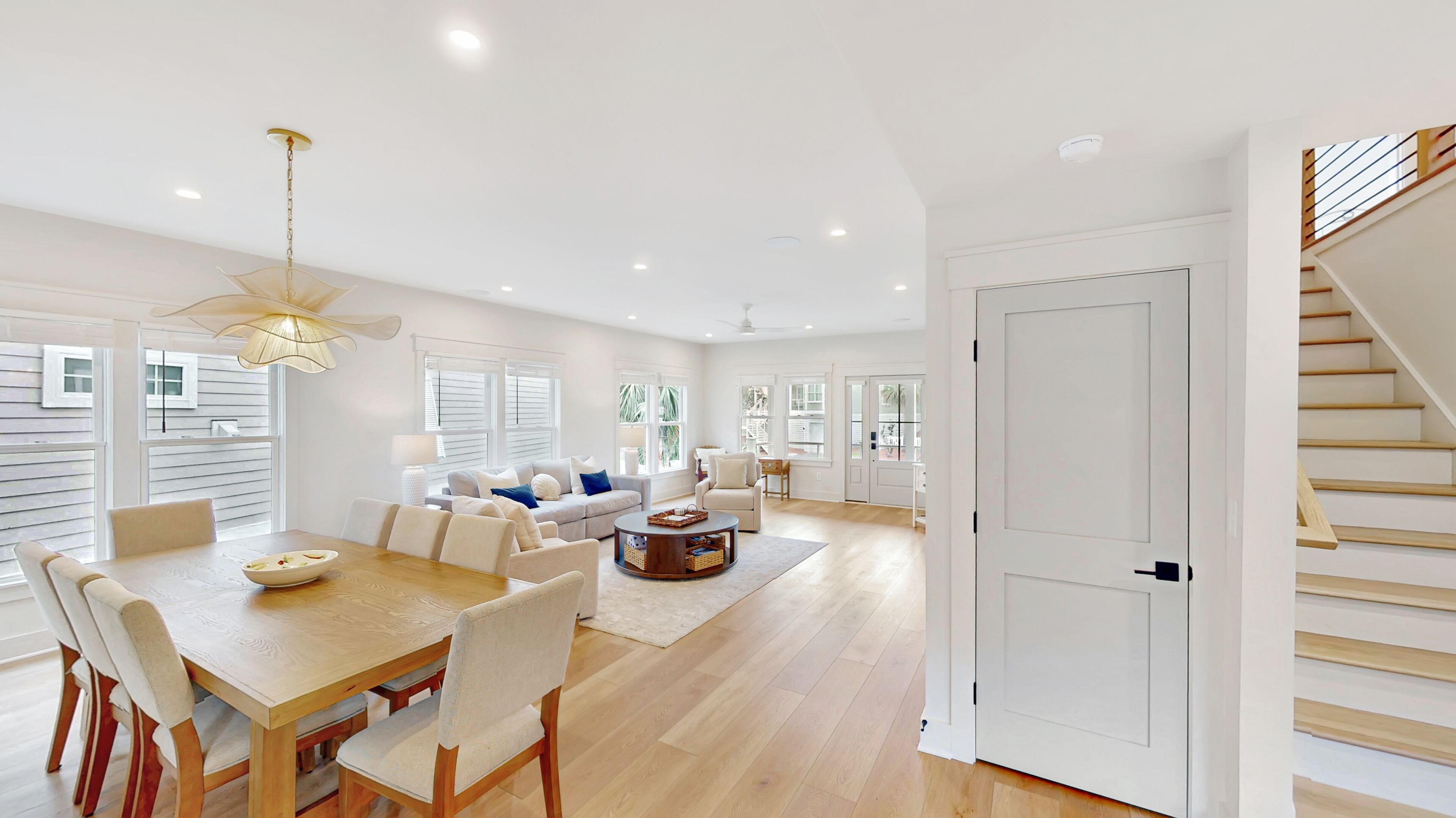 Un espacio habitable amplio con mesa de comedor, sofás y una escalera.