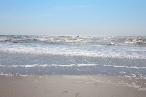 Ein Strand mit an die Küste rollenden Wellen.