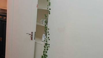 Ein Zimmer mit geschlossener Tür, einem gemusterten Sofa und einer Wand mit Kletterpflanzen.